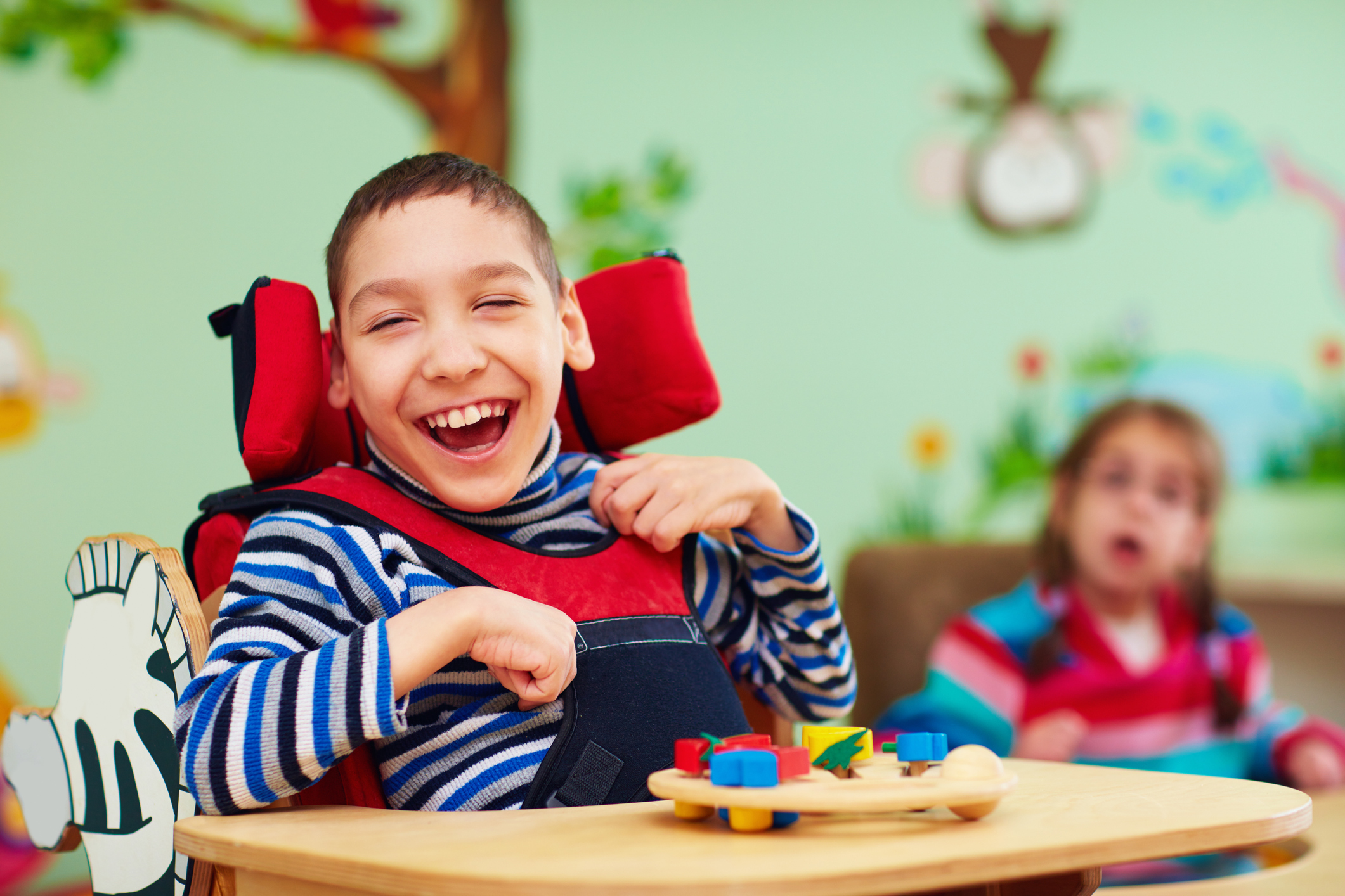 Cheerful boy with disability at rehabilitation center for kids with special needs stock photo
